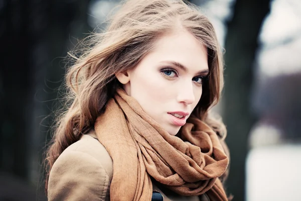 Милая женщина носит бежевый шарф на улице — стоковое фото