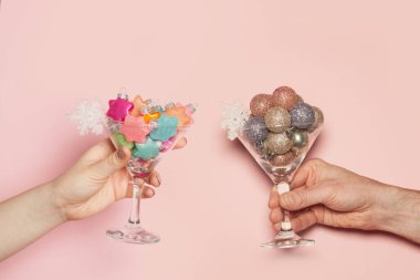 Noel arkaplanı çok az. Noel tostu. Xmas dekorasyonu iki elle pastel pembe arka planda