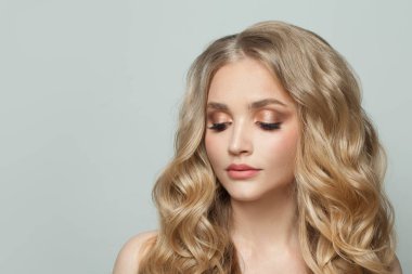 Doğal makyajlı ve kıvırcık saçlı güzel bir kadın.