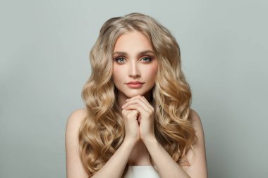 Uzun, sarışın, sağlıklı saçlı ve beyaz arka planda beyaz tenli çekici bir spa mankeni.