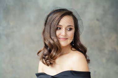 Gri arka planda gülümseyen tatlı bir kadın