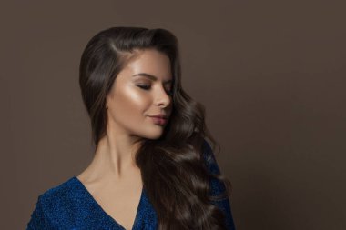 Kahverengi arka planda uzun kıvırcık saçlı güzel model kadın esmer, moda güzeli portresi.