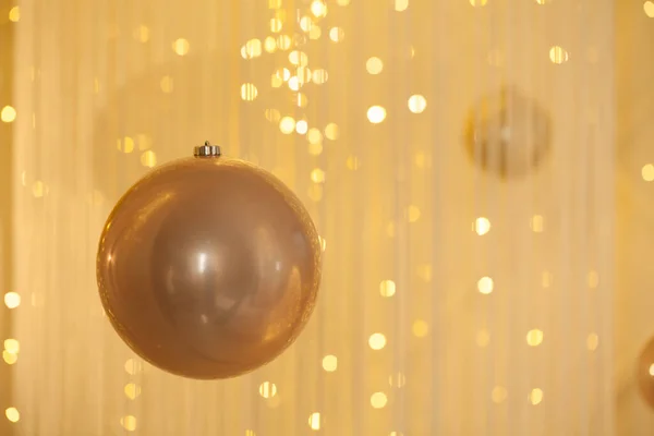 Golden decoration bauble on abstract bokeh glitter light background