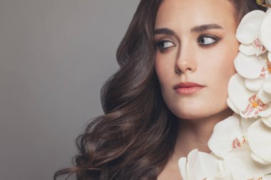 Beyaz orkideli sevimli bir kadın.