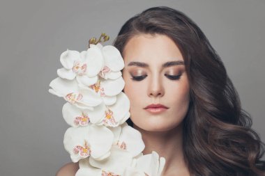 Beyaz orkideli genç ve güzel bir kadın.