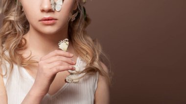 Kahverengi arka planda gül dişi dudaklar ve kelebek