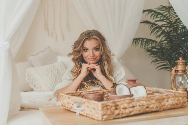 Çekici sarışın kadın gülümsüyor ve dinleniyor tropik bir tatil köyündeki otel odasında