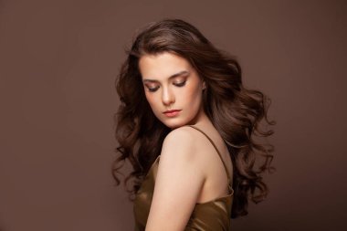 Uzun kıvırcık, siyah saçlı bir kadının portresi. Sağlıklı saçlar, salon bakımı