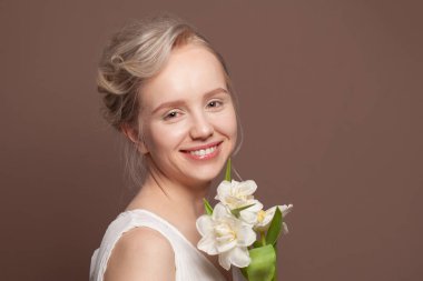 Sevgililer günü, romantizm, kutlama ve güzellik konsepti. Çekici, kadınsı, çiçek alan, elinde güzel bir buket tutan ve neşeyle kahkahalarla gülen genç bir kadın.