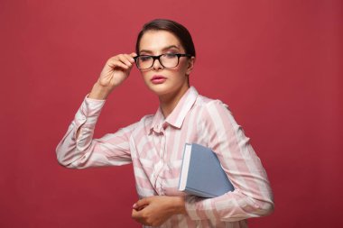 Gözlüklü akıllı kadın kırmızı duvar arkasında izole edilmiş bir şekilde poz veriyor, stüdyo portresi. Kopyalama alanı oluşturun. İnsanlar samimi duygular yaşam tarzı konsepti