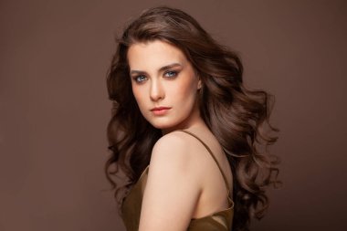 Sağlıklı dalgalı saçlı doğal bir kadın. Makyajlı ve kıvırcık saçlı güzel bir bayan model.
