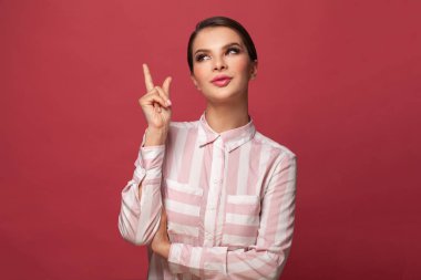 Hoş esmer kadın kırmızı arka planda işaret ediyor.