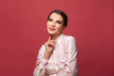 Kırmızı arka planda esmer bir kadın.