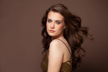 Esmer güzellik. Uzun, kahverengi, rüzgarlı saçları olan hoş bir genç kadın.