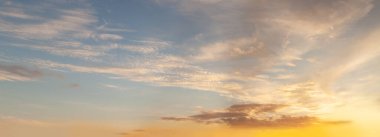 Gökyüzü arka planı. Beyaz kümülüs ve turuncu güneş ışığıyla gökyüzü