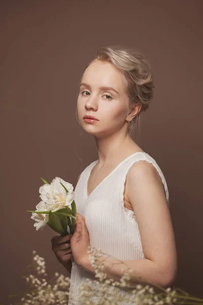 Roztomilá Žena Bílé Košili Drží Bílé Květy Hnědém Pozadí — Stock fotografie