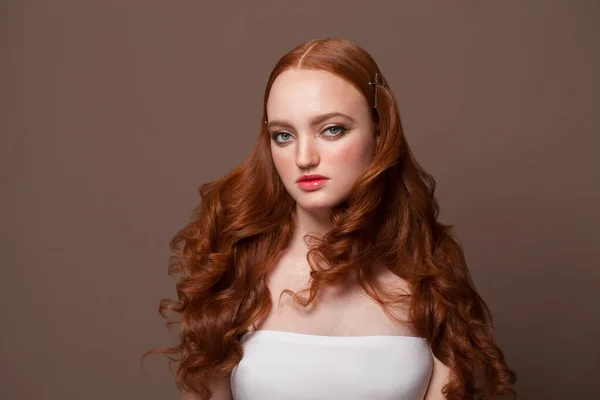 快乐无忧无虑的年轻红头发女人 有着美丽的发型和健康的皮肤 背景是工作室棕色的 — 图库照片