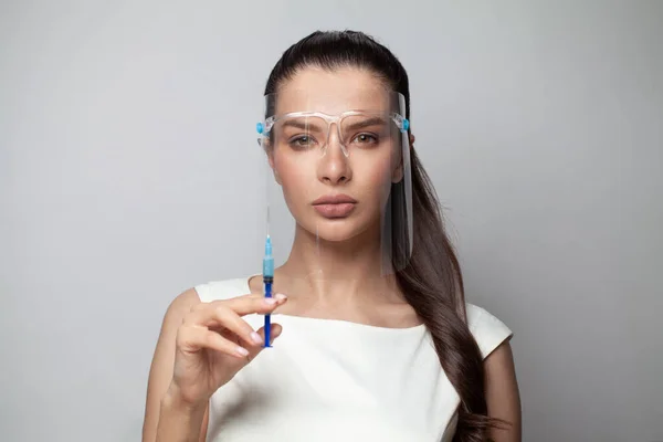 Perfect model woman in face shields with syringe on white background, face close up