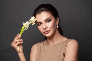 Şık esmer model. Zarif bir tarz ve inci ve pırlanta küpeli.