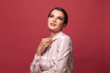 Genç bayan kırmızı arka plana bakıyor.