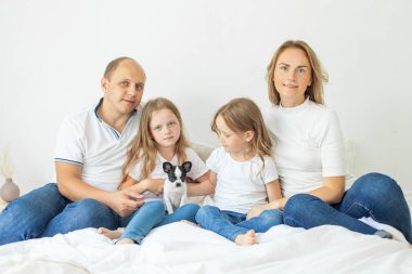 Sevimli aile evde birlikte rahatlar, gülümser ve sarılırlar.