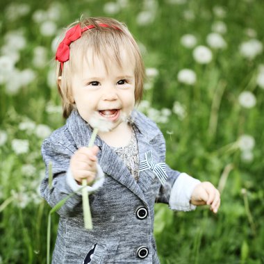 Küçük kız açık havada gülüyor