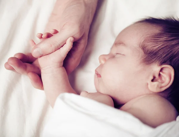 Yeni doğan bebek ve babasının el — Stok fotoğraf