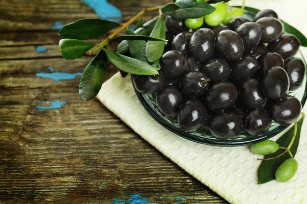 Black olives and green leaves — Stock Photo, Image