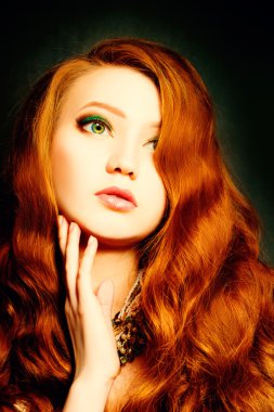 Kıvırcık kırmızı saçlı güzel kadın. Makyaj ve saç