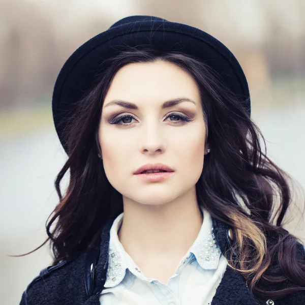 Beautiful young woman in a hat outdoors — Stock Photo, Image