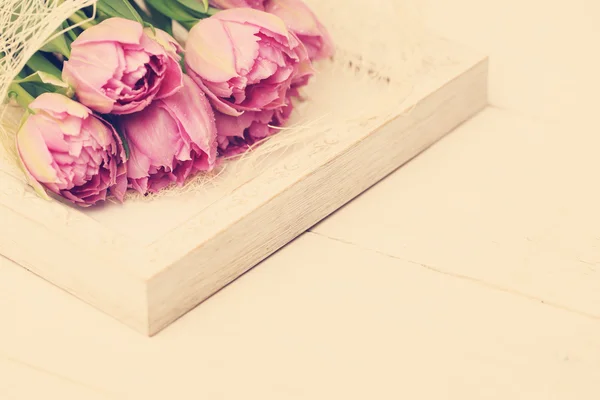 Квіти тюльпан з краплями води і біла старовинна облямівка — стокове фото