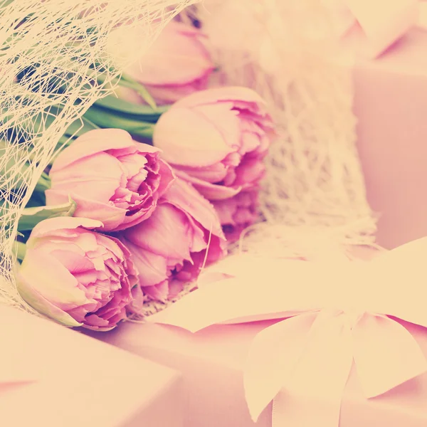 郁金香花和礼物。粉色花背景 — 图库照片