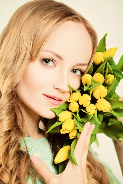 Beauté blonde naturelle. Femme avec des fleurs de tulipes jaunes — Photo