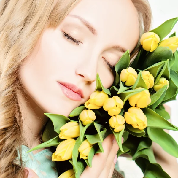 Rostro femenino y flores amarillas de tulipán. Retrato de belleza de la mujer w —  Fotos de Stock