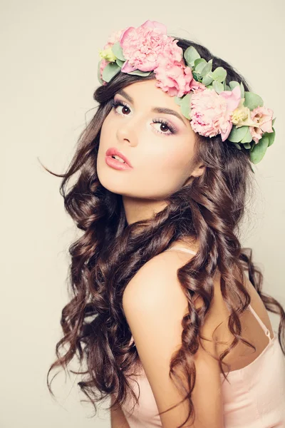 Hermosa mujer joven con flores rosadas de verano. Cabello largo rizado —  Fotos de Stock