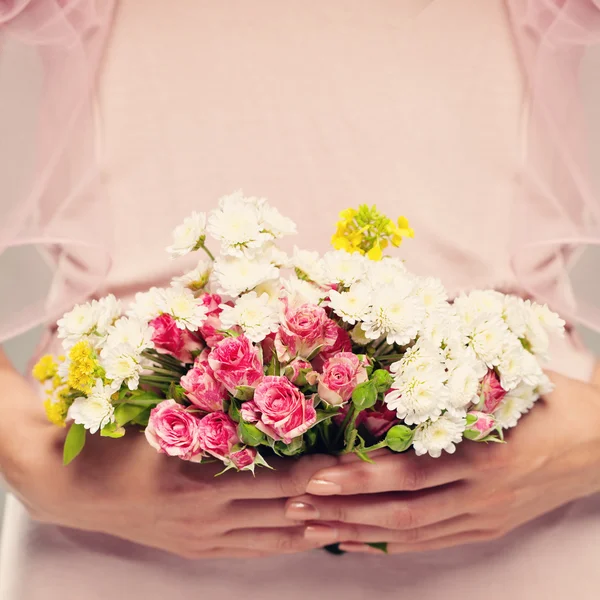 Bloemen Gift in handen van de vrouw. Roze bloemen achtergrond — Stockfoto