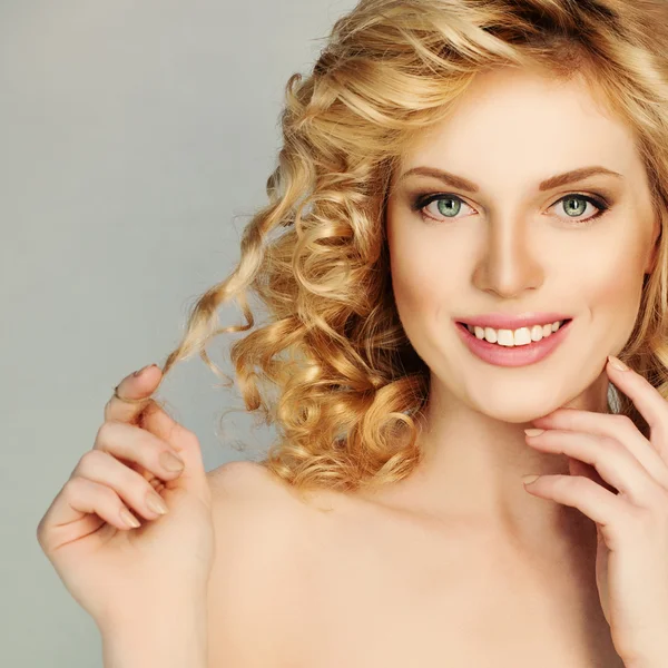 Blond Curly Hair Girl. Mulher sorridente bonita Toque seu cabelo Cu — Fotografia de Stock