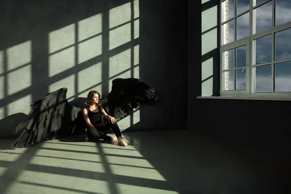 Schwarzer Engel schaut aus dem Fenster. Freiheitskonzept — Stockfoto
