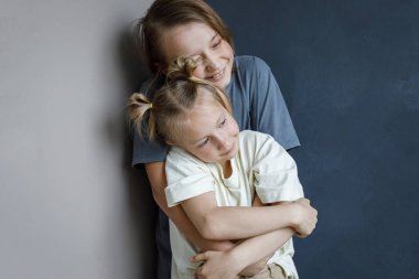 Neşeli genç kız ve erkek kardeş içeride sarılıyor. Kardeş çocuk portresi