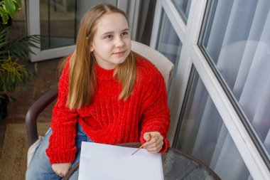 Çizim defterine pembe kedi çizen mutlu çocuk. Genç kız resim yapıyor.