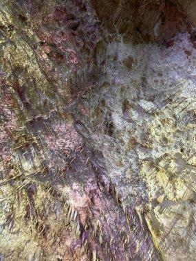 Sarkıtlarla dolu renkli bir mağara yüzeyi