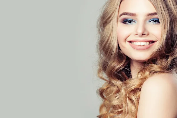 Χαμογελώντας πρότυπο μόδας γυναίκα με ξανθά μαλλιά σγουρά σε φόντο — Φωτογραφία Αρχείου