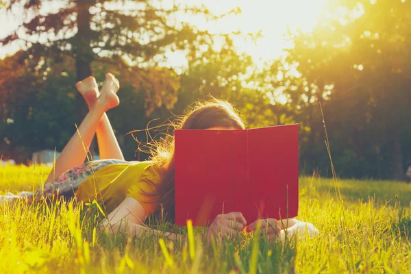 Fille lecture livre dans l'herbe — Photo