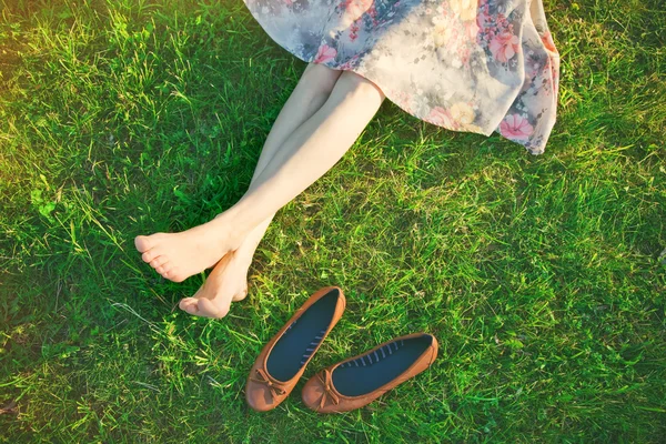 Filles jambes allongées dans l'herbe pieds nus — Photo