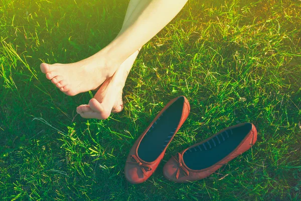 Filles jambes allongées dans l'herbe pieds nus sans chaussures — Photo