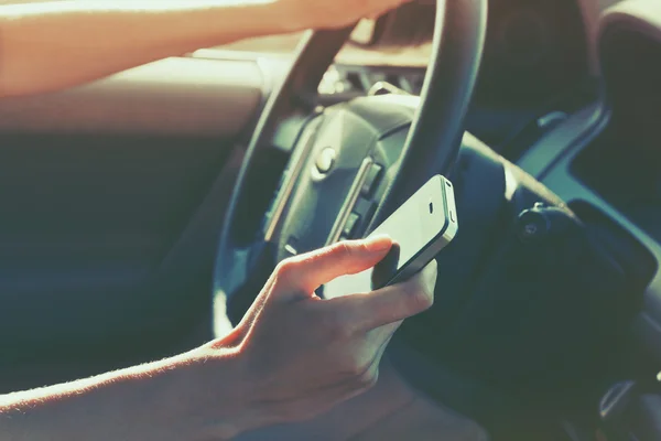 Mano ragazze utilizzando smart phone durante la guida in auto — Foto Stock