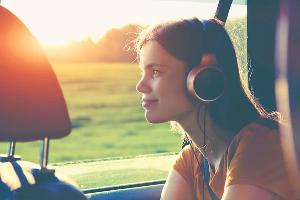 Souriant jolie fille écouter de la musique avec écouteurs — Photo