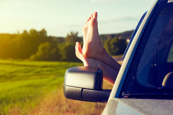 Jambes de femme par la fenêtre de la voiture — Photo