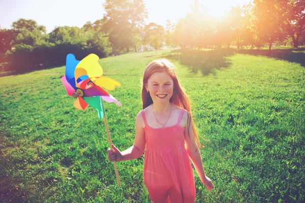 Happy redhead girl with pinwheel toy in park. Freedom, summer, c — Stock Photo, Image