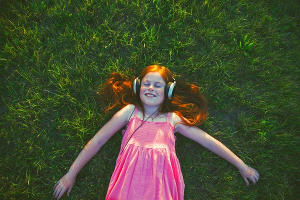 Menina ruiva com fones de ouvido — Fotografia de Stock